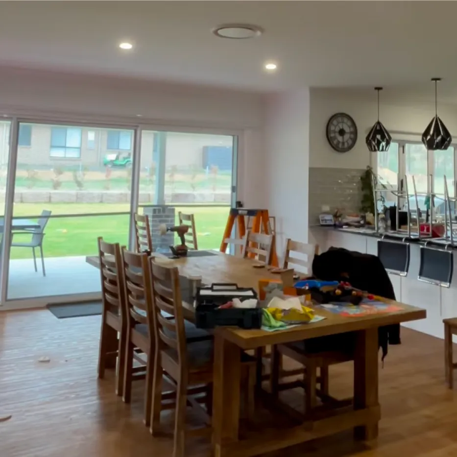 A renovated open-plan dining room with pendant lights and downlights